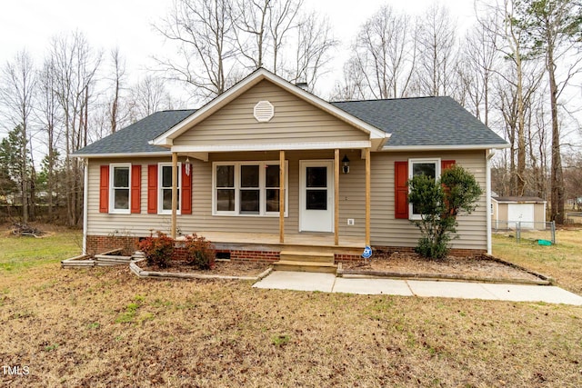 view of front of home with a porch, a front yard, and a shingled roof