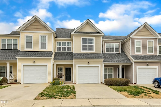 view of property with a garage, roof with shingles, and driveway