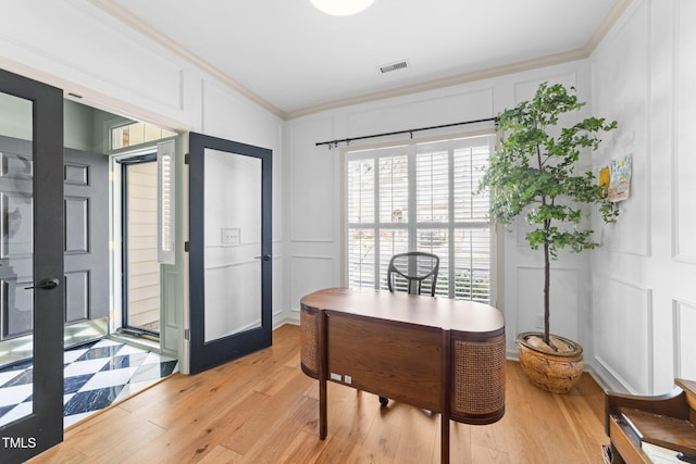 home office with ornamental molding, french doors, visible vents, and a decorative wall