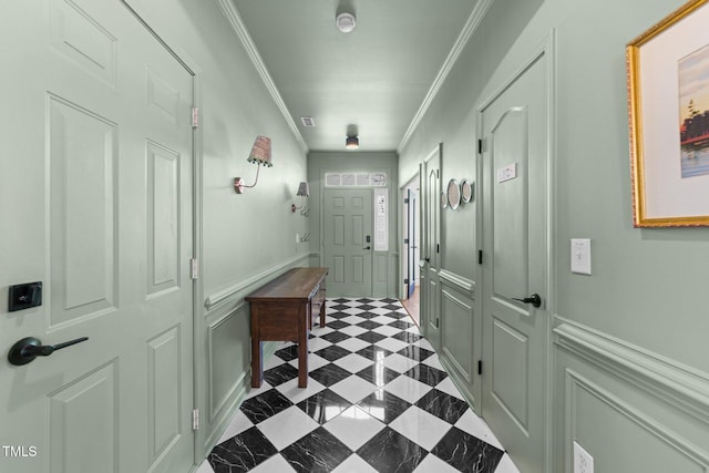 doorway to outside with a wainscoted wall, dark floors, ornamental molding, and a decorative wall