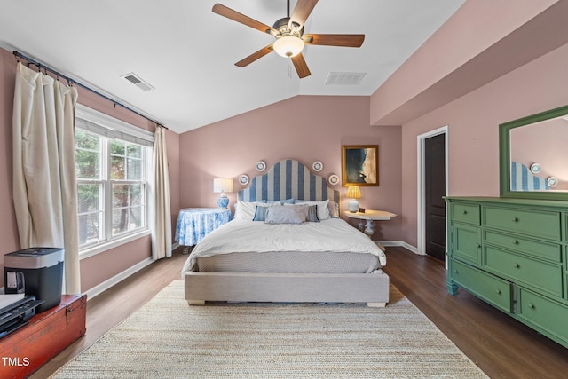 bedroom with baseboards, visible vents, vaulted ceiling, and dark wood finished floors