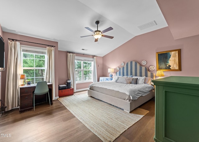 bedroom featuring ceiling fan, visible vents, vaulted ceiling, and wood finished floors