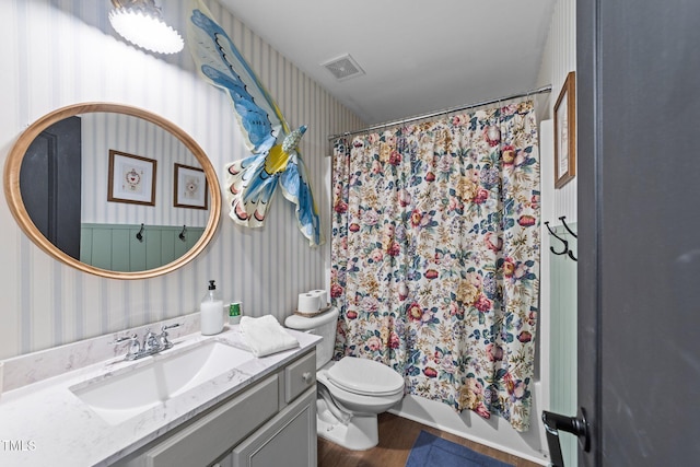 bathroom with visible vents, vanity, toilet, and wallpapered walls