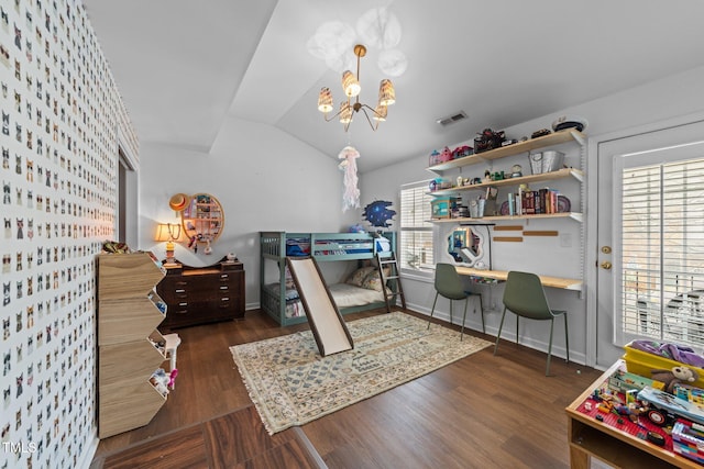 bedroom with lofted ceiling, visible vents, wood finished floors, a chandelier, and baseboards