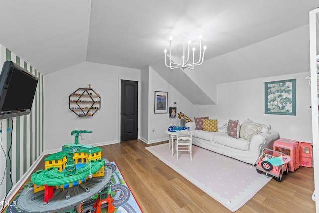 recreation room featuring lofted ceiling, a notable chandelier, baseboards, and wood finished floors