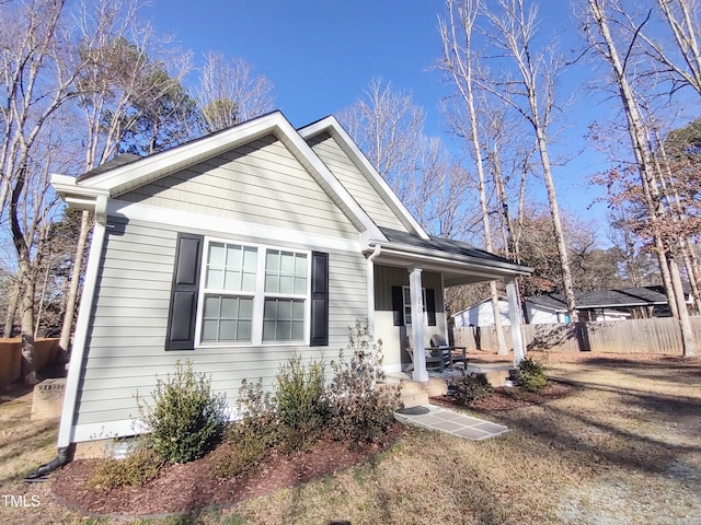 view of front facade featuring covered porch and fence