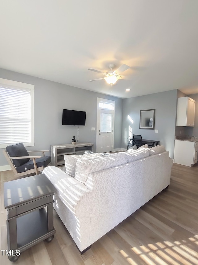 living room with light wood-style floors and a ceiling fan