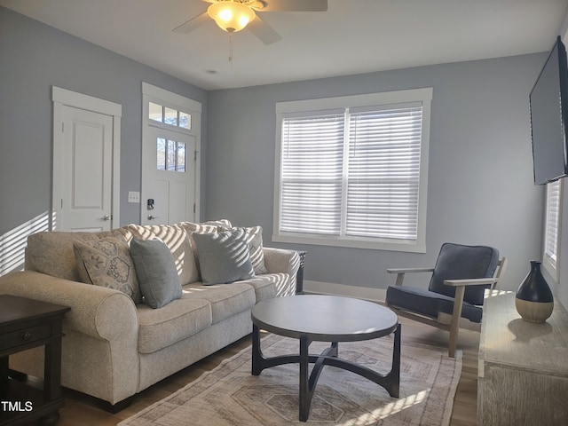 living room with ceiling fan, wood finished floors, and a healthy amount of sunlight