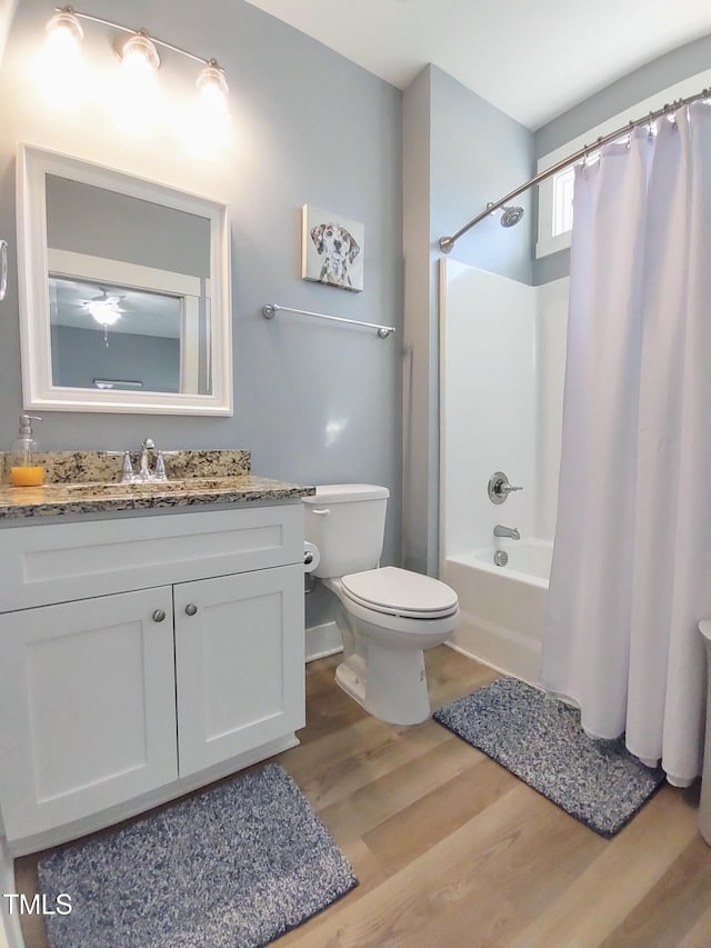 bathroom with shower / tub combo with curtain, vanity, toilet, and wood finished floors