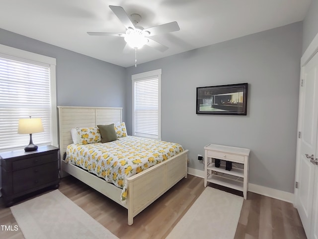 bedroom featuring ceiling fan, baseboards, and wood finished floors