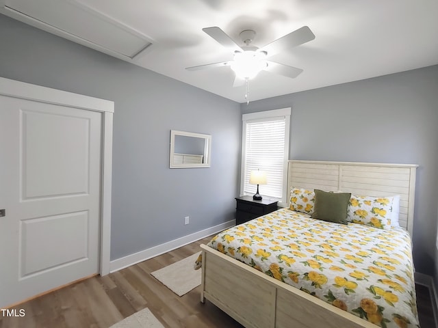 bedroom featuring wood finished floors, a ceiling fan, and baseboards