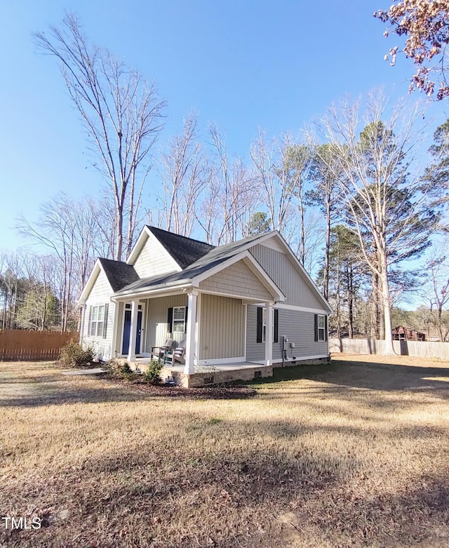 view of front of home with a front lawn, fence, and a porch