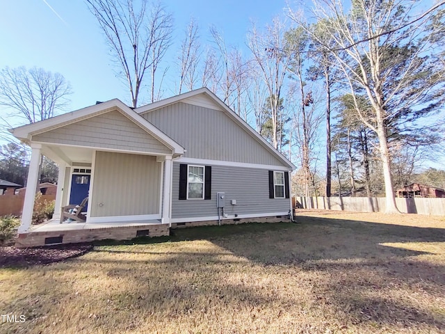 rear view of property featuring a porch, crawl space, fence, and a lawn