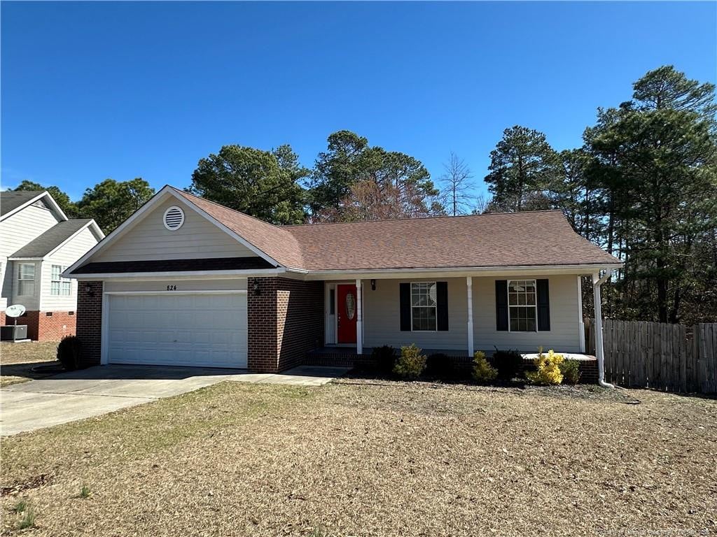 single story home with a porch, a garage, brick siding, fence, and driveway