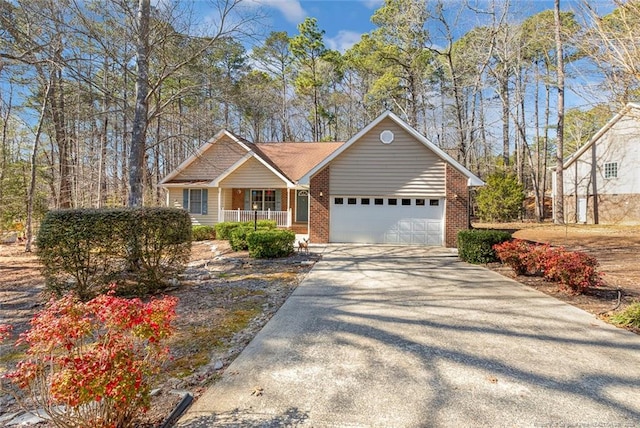 view of front facade featuring a porch, brick siding, driveway, and a garage