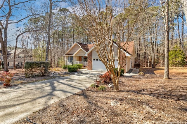 view of front of house featuring an attached garage, covered porch, concrete driveway, and brick siding