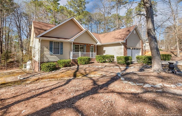 ranch-style house featuring covered porch, brick siding, and a garage