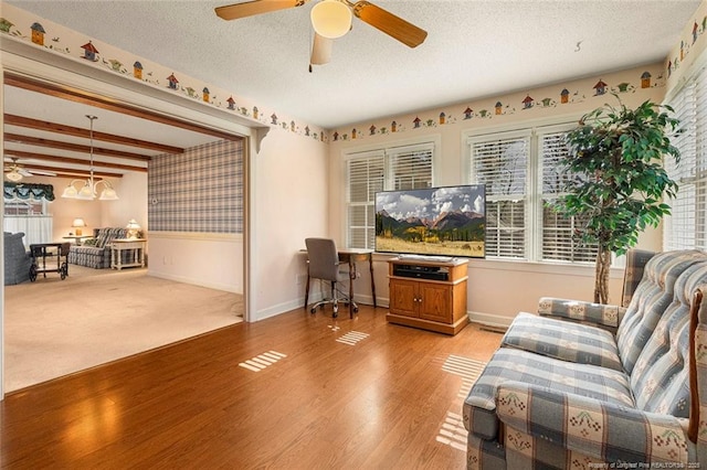 living area featuring a ceiling fan, a wealth of natural light, a textured ceiling, and light wood finished floors