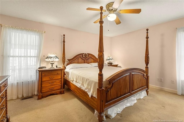 bedroom featuring baseboards, a ceiling fan, visible vents, and light colored carpet