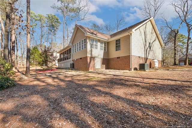 view of side of property featuring central air condition unit and brick siding