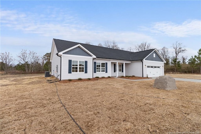 single story home featuring a shingled roof, concrete driveway, an attached garage, board and batten siding, and cooling unit