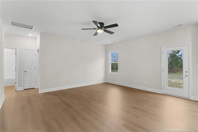 unfurnished room featuring a ceiling fan, baseboards, visible vents, and light wood finished floors