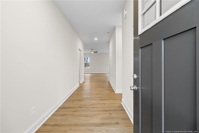 hallway with recessed lighting, baseboards, and light wood finished floors