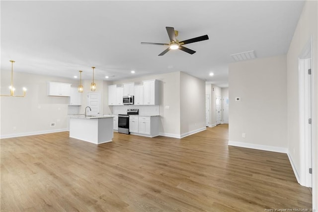 unfurnished living room featuring light wood-type flooring, recessed lighting, baseboards, and ceiling fan with notable chandelier