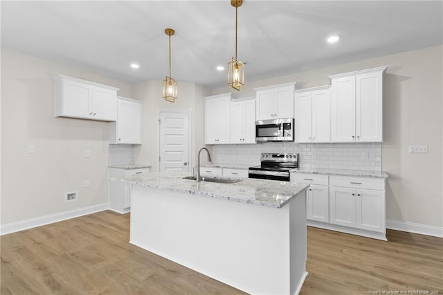 kitchen with stainless steel appliances, a sink, light wood-style flooring, and white cabinets