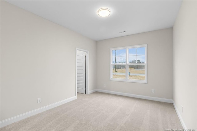 unfurnished room with light carpet, visible vents, and baseboards