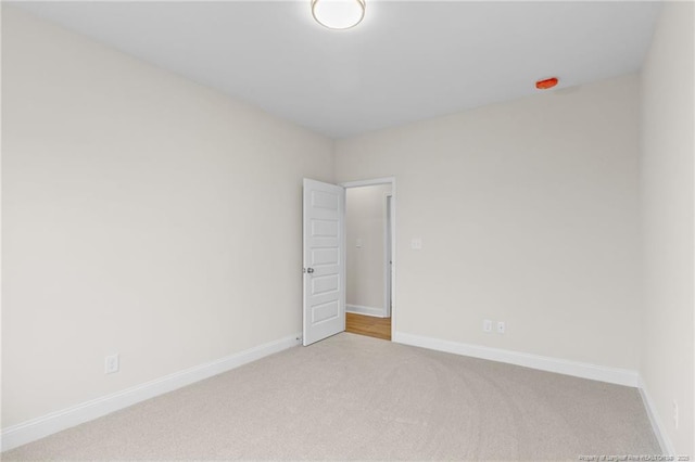 carpeted spare room featuring baseboards