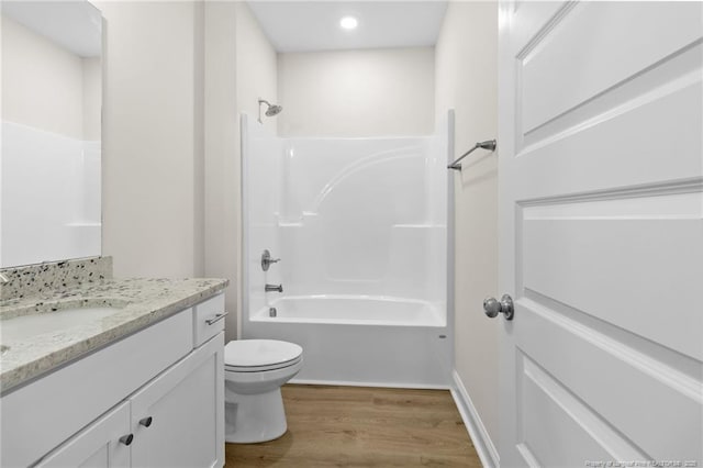 full bath featuring vanity, shower / tub combination, wood finished floors, and toilet