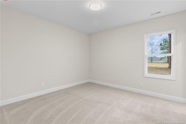 empty room with visible vents, baseboards, and light colored carpet