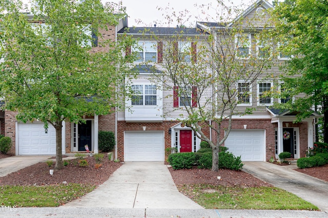 multi unit property with an attached garage, concrete driveway, and brick siding