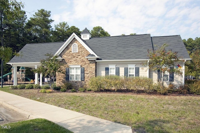 view of front facade featuring a front yard and stone siding