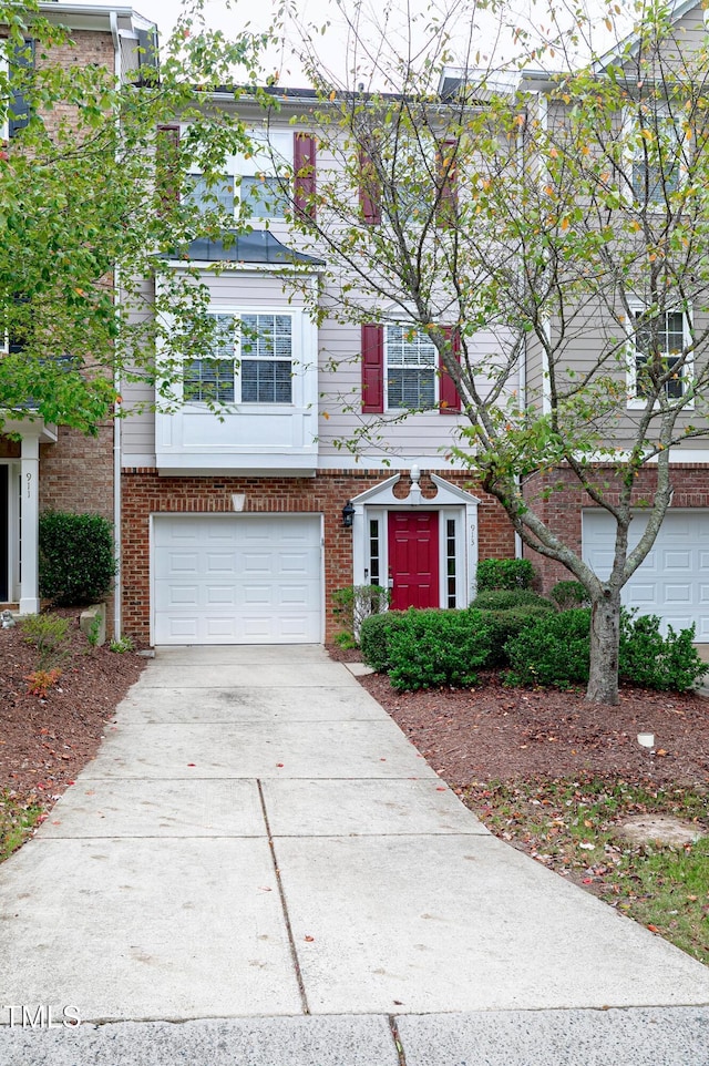 view of front of property with a garage, concrete driveway, and brick siding