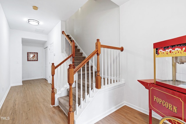 stairway with wood finished floors and baseboards