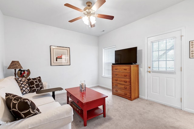 living area featuring light carpet, ceiling fan, visible vents, and baseboards