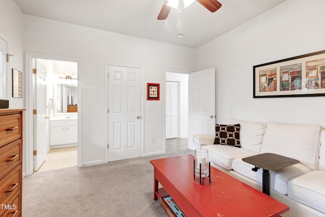 living room with light colored carpet, ceiling fan, and baseboards