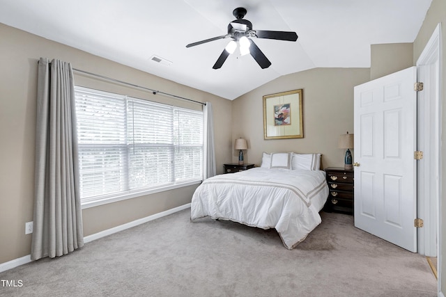 bedroom featuring baseboards, visible vents, light colored carpet, ceiling fan, and vaulted ceiling