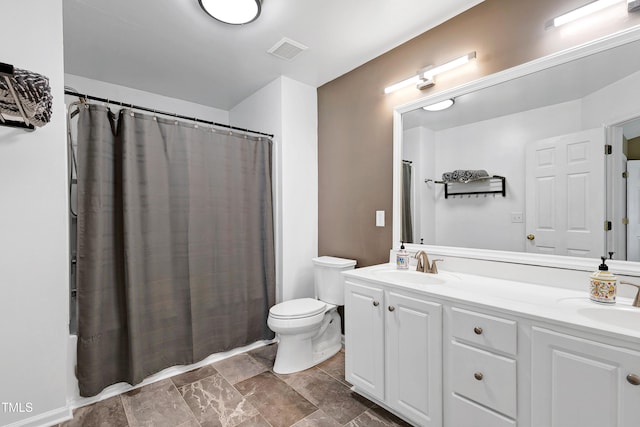 bathroom with double vanity, visible vents, toilet, and a sink