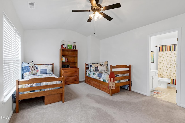 bedroom with carpet, lofted ceiling, visible vents, a ceiling fan, and connected bathroom