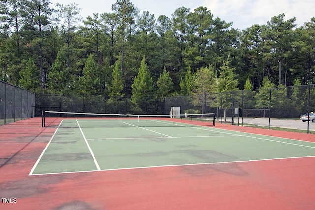 view of tennis court with community basketball court and fence