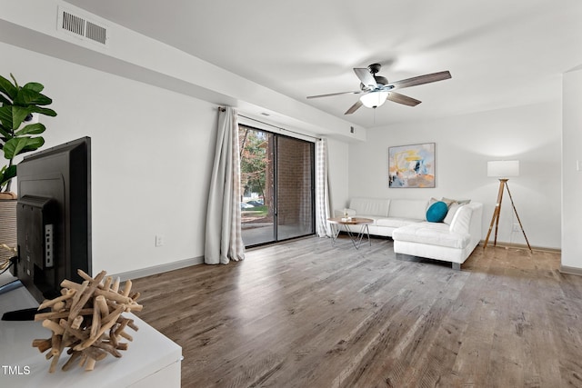 living room with visible vents, baseboards, wood finished floors, and a ceiling fan