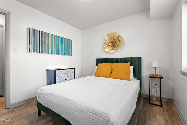 bedroom with wood finished floors and baseboards