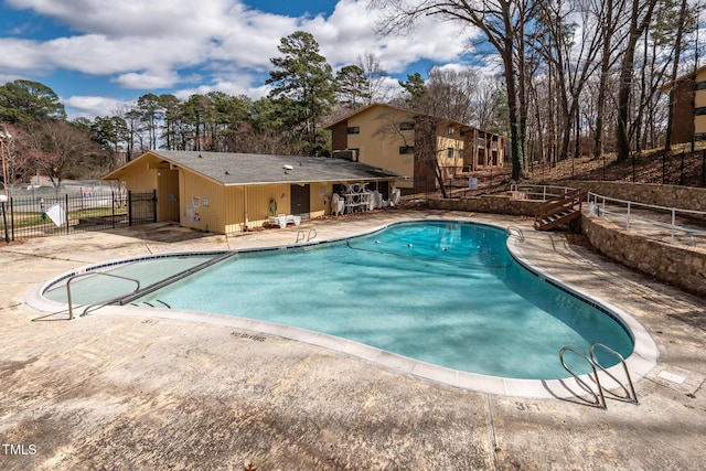 community pool featuring a patio and fence