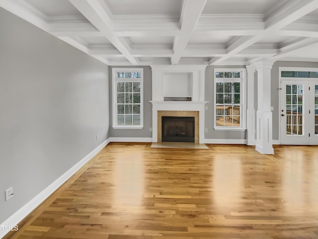 unfurnished living room with a fireplace with flush hearth, baseboards, a healthy amount of sunlight, and light wood finished floors