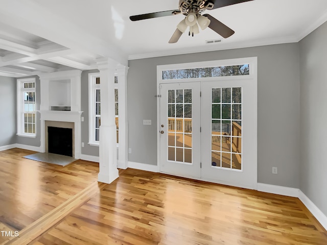 doorway to outside featuring decorative columns, baseboards, visible vents, ornamental molding, and wood finished floors