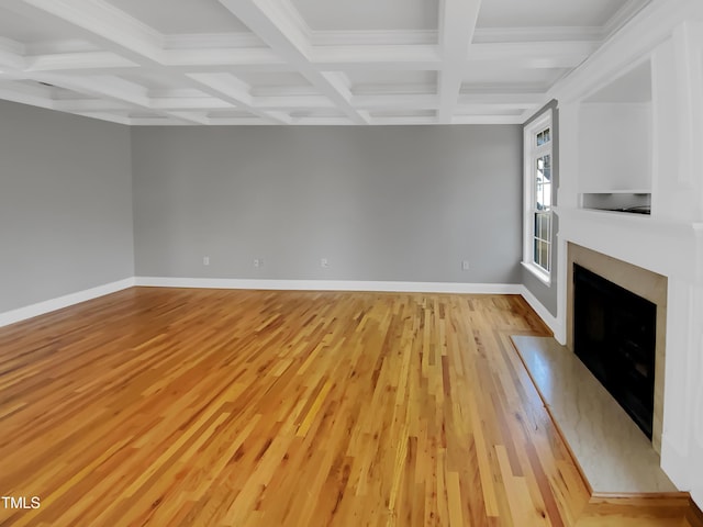 unfurnished living room featuring baseboards, coffered ceiling, a fireplace with flush hearth, light wood-style flooring, and beam ceiling