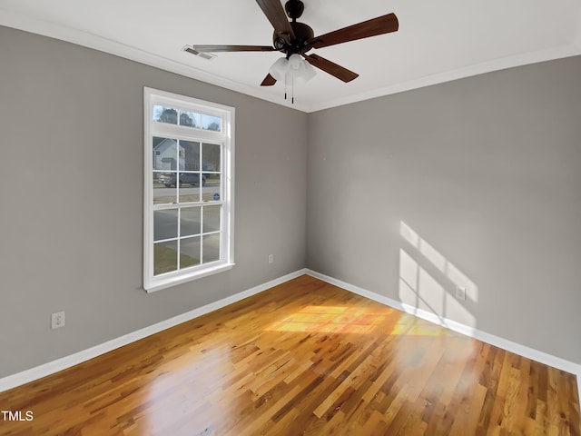 unfurnished room with ceiling fan, crown molding, baseboards, and wood finished floors